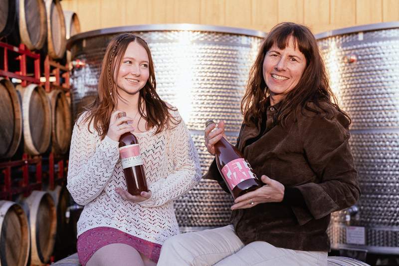 Tracey Rogers brandt and Isabel Brandt each holding a bottle of wine