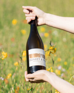 Linda Vista Chardonnay bottle being held in tall grass 