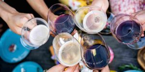 people clinking wine glasses from above